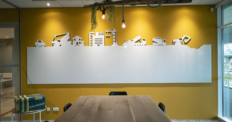 Bespoke whiteboard wall with a city skyline cutout above a meeting table