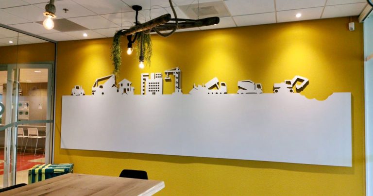 Close view of construction vehicle silhouettes cut into a bespoke whiteboard wall