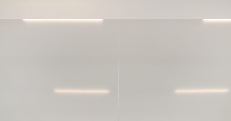 Close-up of the panel joint on a ceramic steel whiteboard showing overhead light reflections