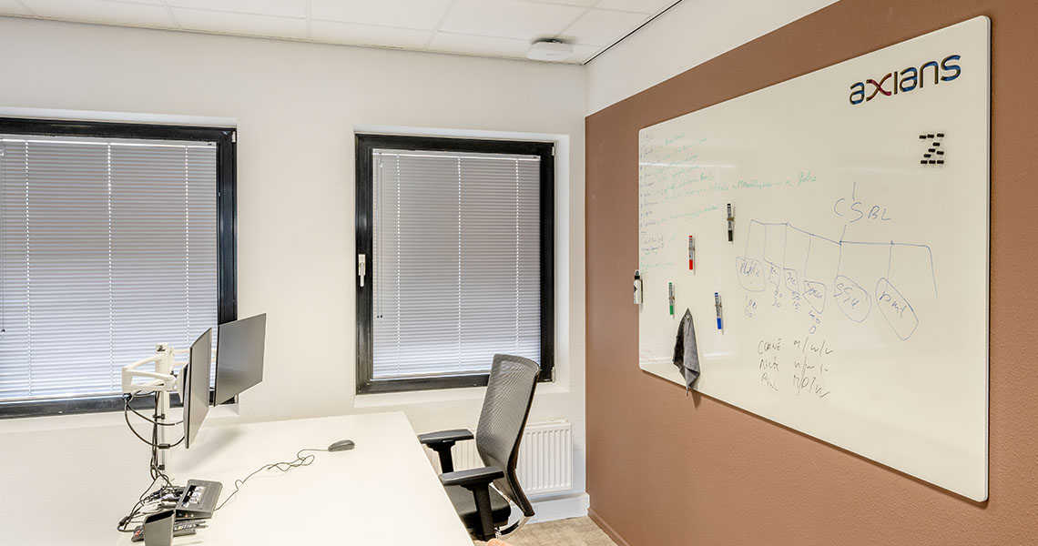 Custom whiteboard wall in a bright, plant-filled office corner