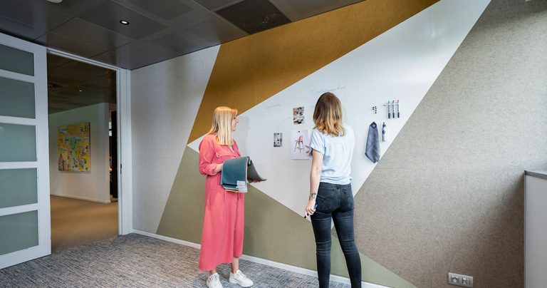 Custom whiteboard wall integrated into a geometric office wall pattern