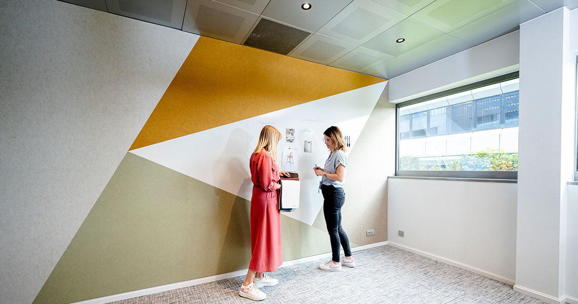 Two employees discussing colour samples at a custom whiteboard wall