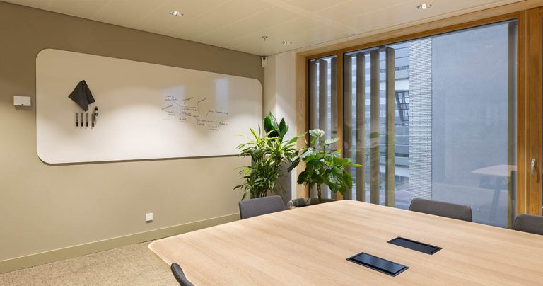 Frameless whiteboard installed in a meeting room setting