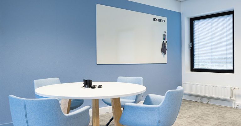 Large whiteboard mounted in an open-plan office