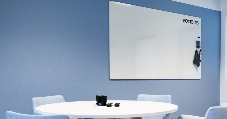 Large branded whiteboard mounted in a blue-toned meeting room
