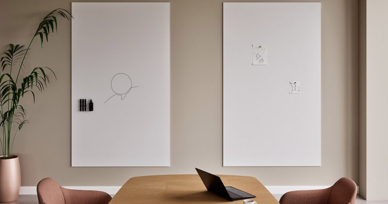 Large whiteboard positioned beside a conference table
