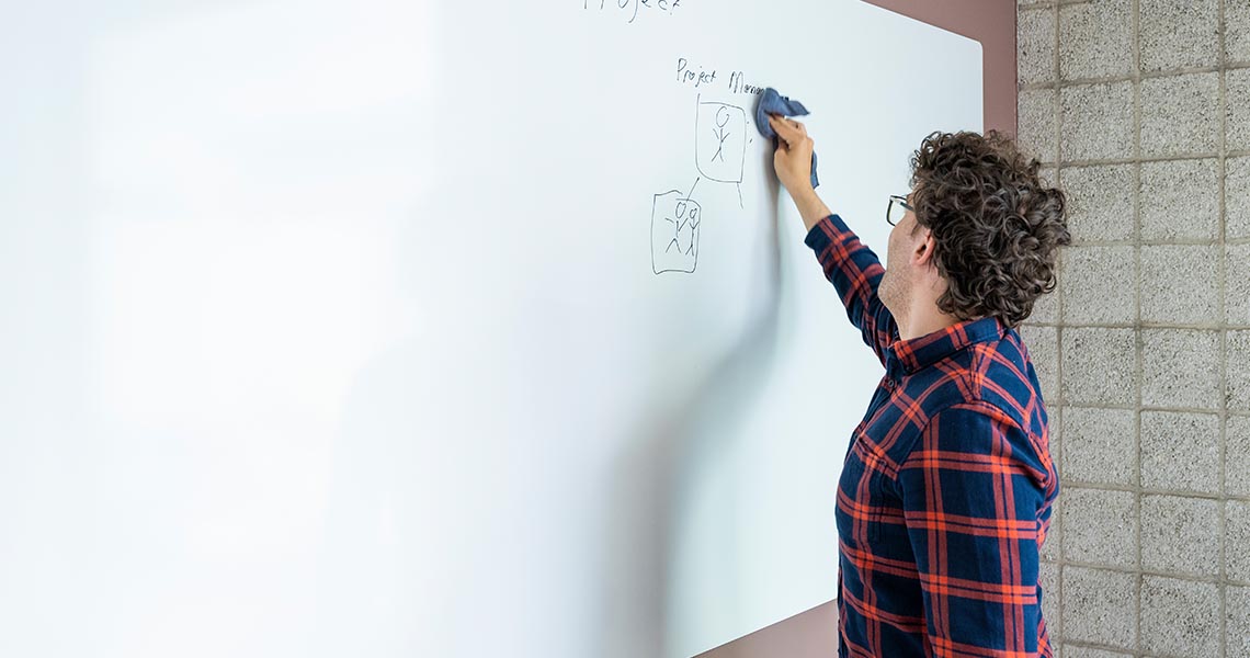Corner view of a whiteboard wall wrapping around an office meeting room