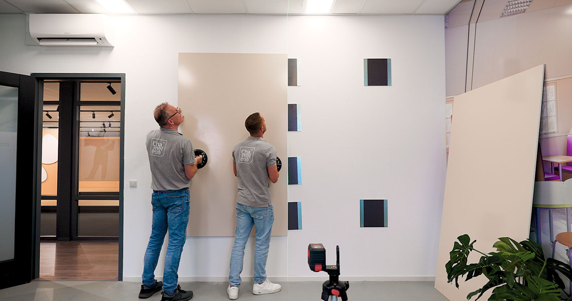 Whiteboard wall in a glass-walled meeting room seen from the corridor