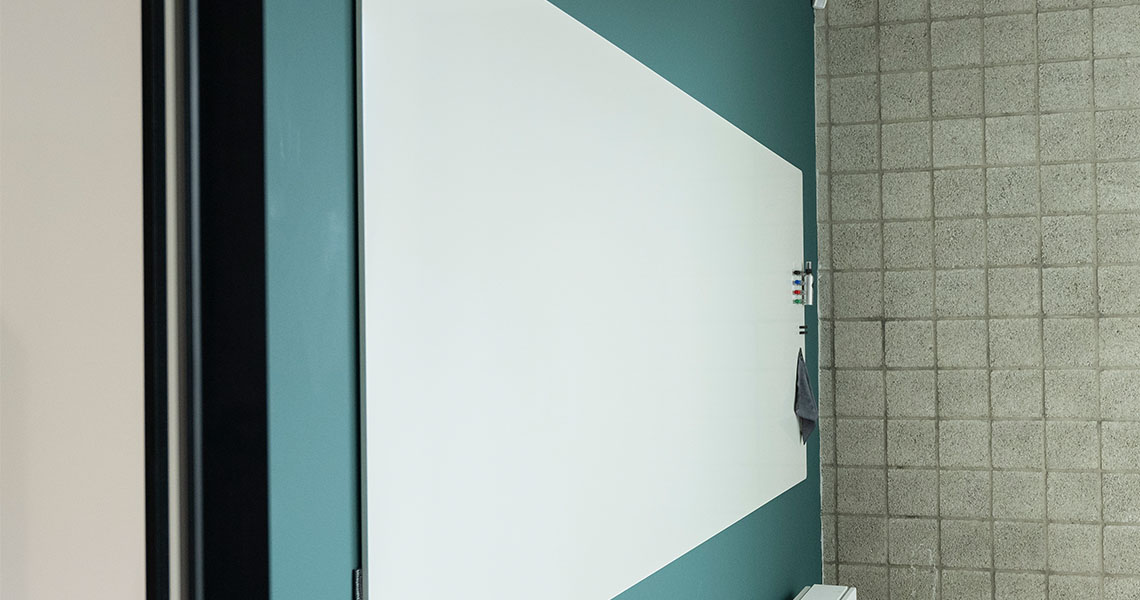 Whiteboard wall installed across an office wall