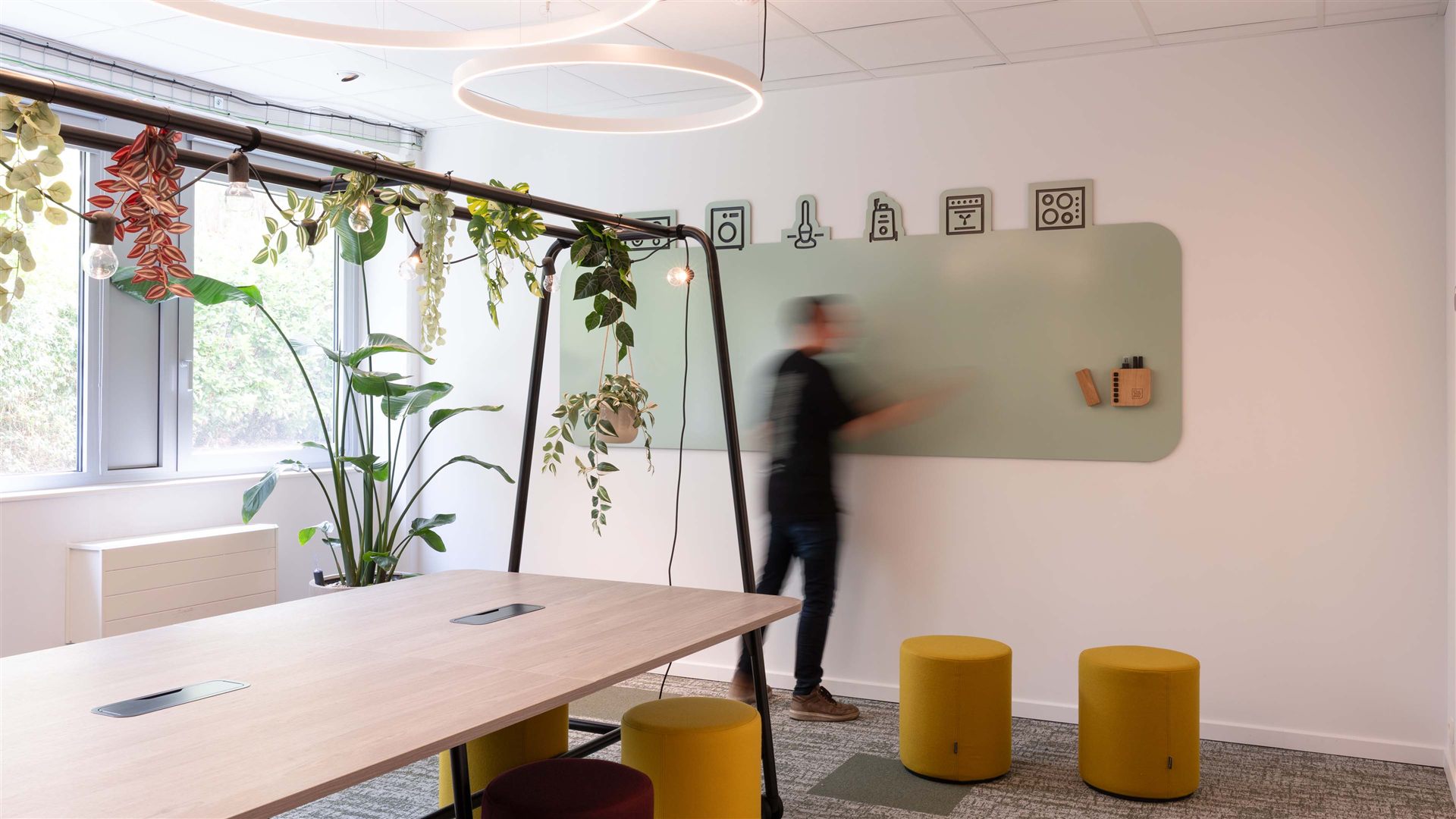 Weitere Ansicht des Whiteboards nach Maß mit einer vorbeigehenden Person, sichtbar sind die abgerundeten Ecken und die volle Breite der Tafel.
