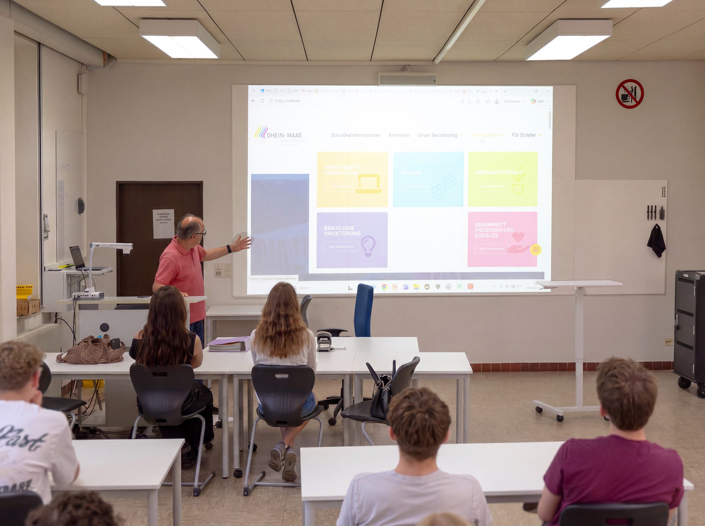Un enseignant donne cours avec un Hybrid Projection Wall dans une salle de classe du Rhein-Maas-Berufskolleg