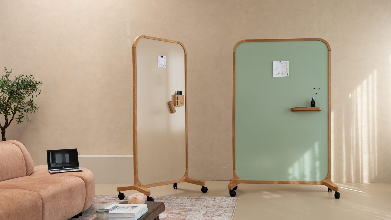 Mobile whiteboard on wheels in a lounge corner with a sofa and plant