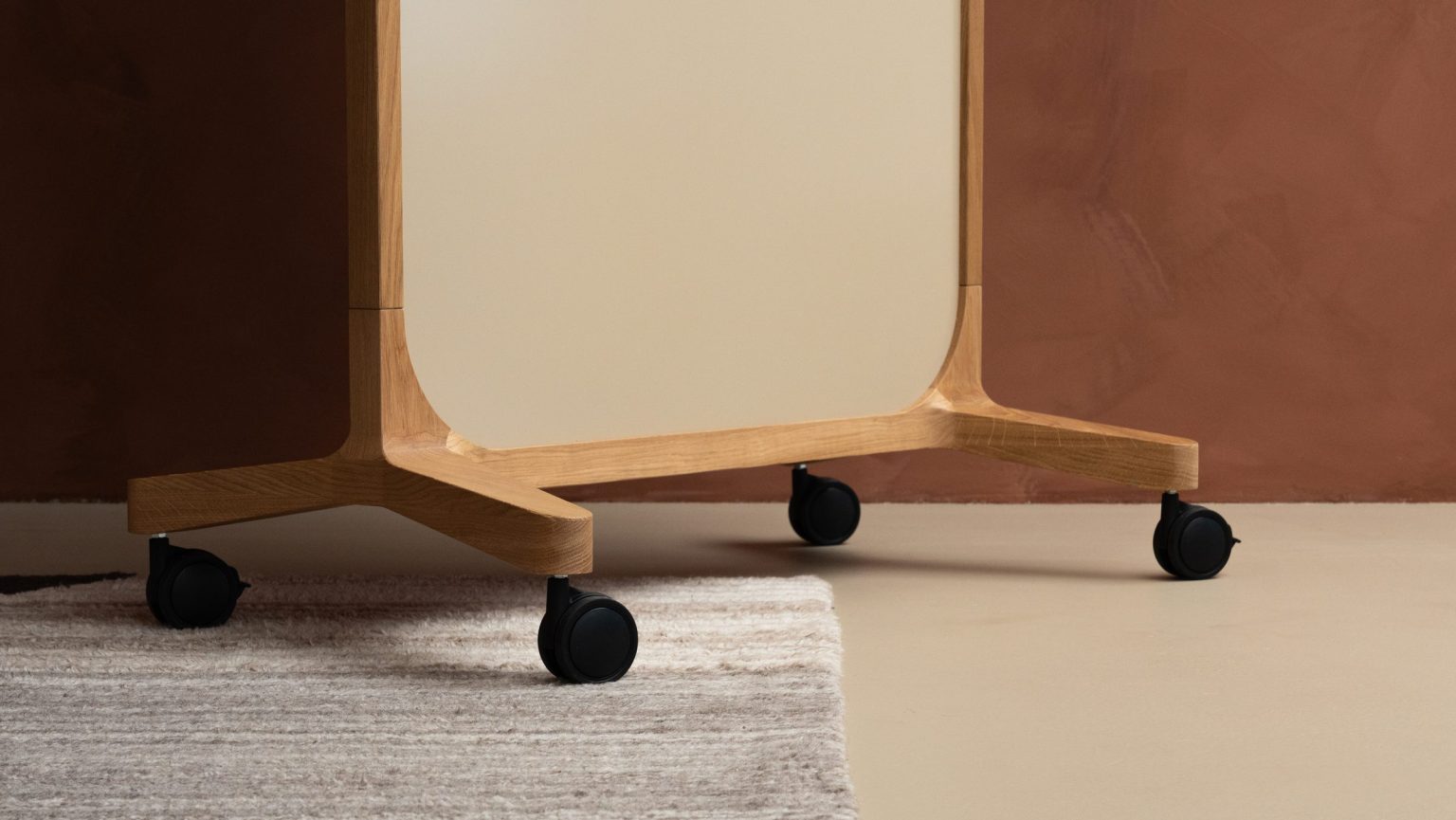 Wheels of a mobile whiteboard on a rug