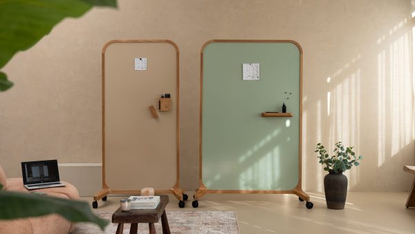 Twee mobiele whiteboards op wielen in beige en saliegroen in een loungeruimte
