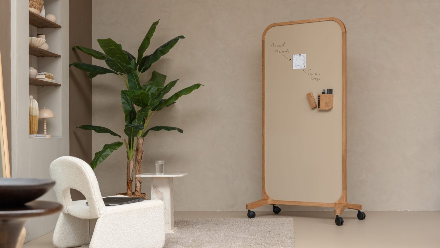Minimalistische hoek met mobiel whiteboard op wielen, stoel en plant