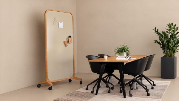 Mobiel whiteboard op wielen bij een vergadertafel met stoelen